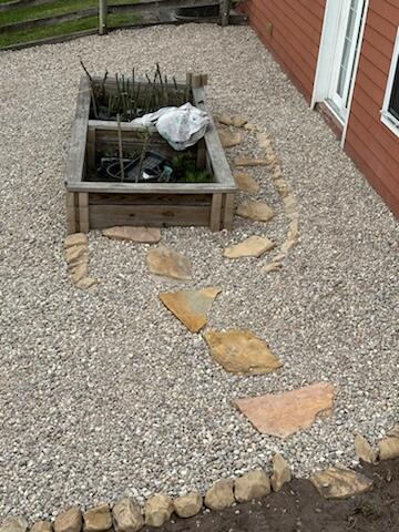 Gravel and a stone path next to a barn.