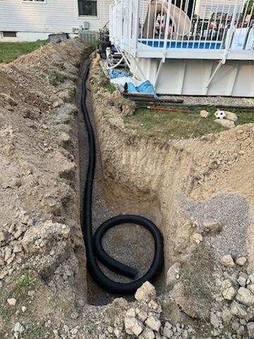 Drain pipes laid in a trench next to a pool.