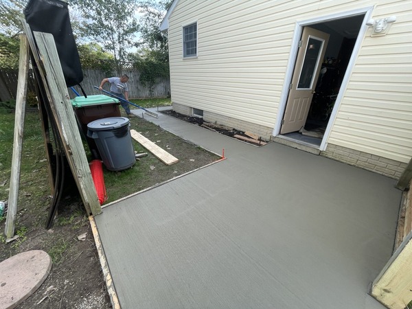 Finishing a concrete pad next to a house.