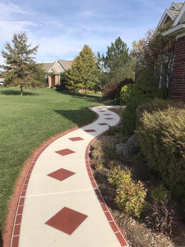 A concrete walkway with a red diamond pattern.