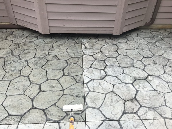 A stamped concrete patio being sealed.